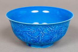 A Chinse porcelain bowl With allover blue glaze and worked with dragons amongst stylised clouds,