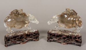 A pair of Chinese carved rock crystal models of buffalo Each typically modelled with a child on its