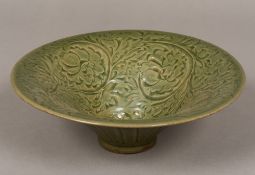 A Chinese celadon ground bowl Of spreading form, worked with scrolling floral sprays.
