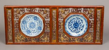A pair of Chinese blue and white porcelain plates Mounted in a carved pierced giltwood double frame,