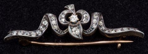 A Victorian unmarked gold and diamond bar brooch Of scrolling ribbon form. 4.5 cm long.