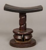 An African tribal carved wooden headrest With curved top above the turned column,