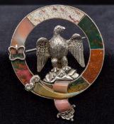 A Scottish unmarked silver and specimen agate set brooch Of circular form, centred with an eagle.