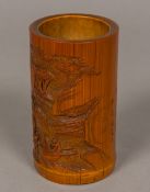 A 19th century Chinese bamboo brush pot Well carved with figures in a mountainous landscape