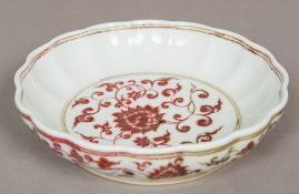 A Chinese porcelain bowl Decorated in iron red with lotus strapwork within a wavy rim. 20.