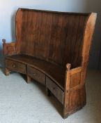 A 19th century fruitwood and pine settle Of planked barrel backed form,