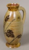 A late 19th/early 20th century Martin Brothers pottery ewer Decorated with wild flowers,