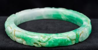 A large Chinese carved jade bangle Decorated in the round with various animals amongst scrolling