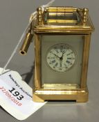 A miniature carriage clock with painted porcelain panels