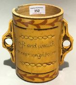 A 19th century Slipware pottery twin handled vessel inscribed Thrift And Wealth Are Near Neighbours