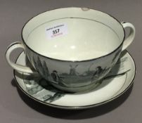 A large 19th century Creamware porcelain twin handled cup and saucer