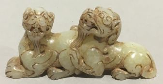 A Chinese jade carving formed as two dogs-of-fo