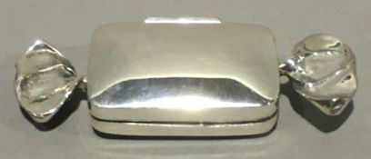 A silver pill box formed as a sweet
