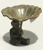 A Chinese bronze model of a boy holding a lily pad