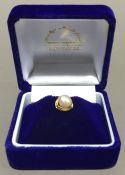 An 18 ct gold and pearl mounted lapel pin