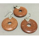A silver and goldstone pendant and earrings