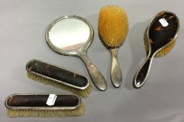 A silver mounted tortoiseshell dressing table set, comprising: two clothes brushes,