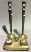 A brass Art Nouveau inkwell and a pair of candlesticks