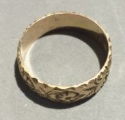 A 9 ct gold wedding band with floral engravings (3.