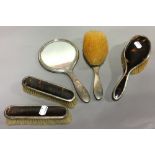 A silver mounted tortoiseshell dressing table set, comprising: two clothes brushes,