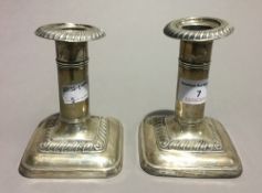 A silver mirror and a pair of silver dwarf candlesticks