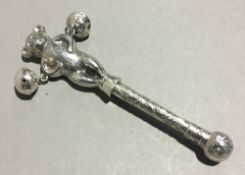 A silver rattle in the form of a teddy bear