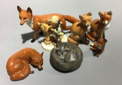 A collection of porcelain model foxes and a Hummel figure