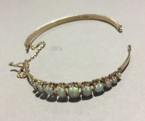 A 9 ct gold opal set hinged bangle (a/f) (10.