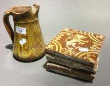 An antique slipware jug and antique tiles