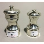 Two silver pepper grinders
