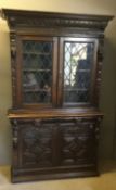 A Victorian carved oak glazed cabinet