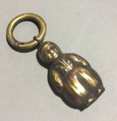 A brass rattle formed as a Dutch boy