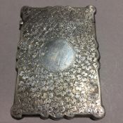 A silver card case decorated with clovers