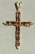 A 9 ct gold, garnet and diamond cross (1.