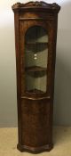 A bow fronted glazed walnut corner cabinet