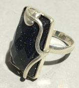 A silver and goldstone purple ring