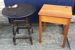 A small wooden school desk with lift up-lid and a mid 20th century round wooden pub table