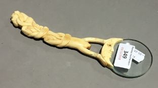A magnifying glass with monkey bone carved handle