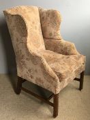 A late George III mahogany framed wing armchair, later upholstered and with cushion seat.