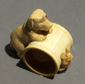 A bone napkin ring carved with a dog and a frog