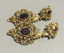 A pair of 9 ct gold gem set open scroll work pendant earrings (9 grammes total weight)