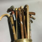 A quantity of walking sticks in a brass stick stand