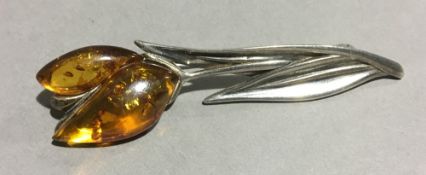 A silver amber flower brooch