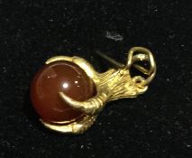 A 9 ct gold eagle claw and agate pendant