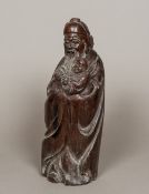 A Chinese carved hardwood figure of a deity Modelled in flowing robes holding a child. 38 cm high.