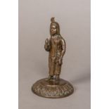 A 19th century Indian patinated bronze figure Modelled standing in flowing robes and a headdress,