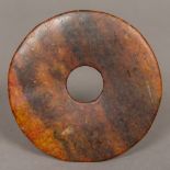 A Chinese russet jade bi disc Of typical form. 8.5 cm diameter.