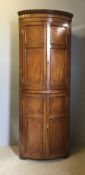 A Regency mahogany floor standing bow fronted corner cabinet The moulded shaped cornice above twin