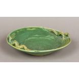 A large Oriental pottery bowl With allover mottled green glazed, the rim set with two dragons,