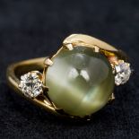 An 18 ct gold chrysoberyl cats eye and diamond cross over ring The two diamonds totalling